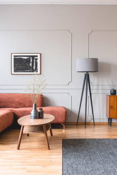 istock Stylish tall grey lamp in elegant living room interior with comfortable brown corner sofa 1196385552