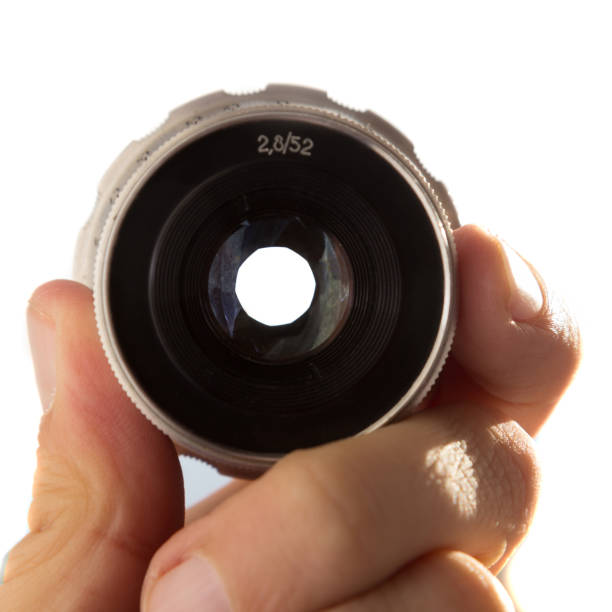 istock Hand holding camera lens on white background 1196385588
