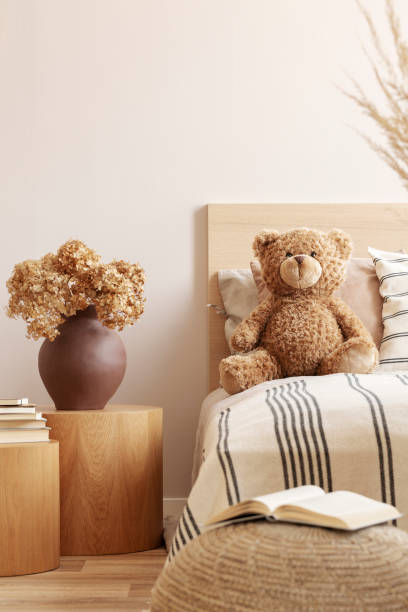 istock Cute teddy bear on single bed in natural kid's room 1196385671
