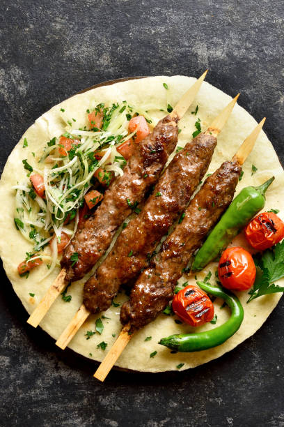 istock Turkish Adana Kebab with fresh vegetables on flatbread 1196388332