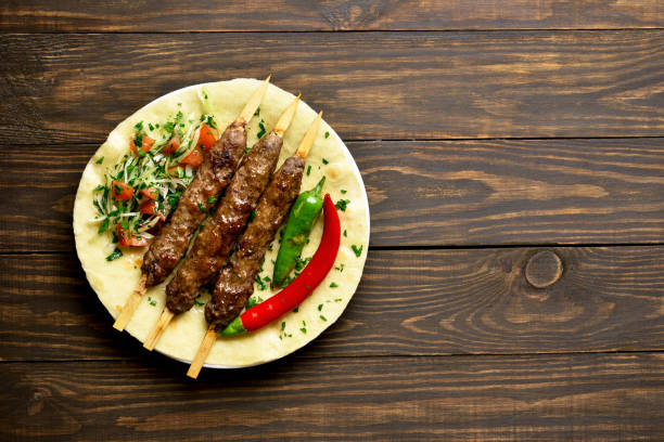 istock Turkish Adana Kebab with fresh vegetables on flatbread 1196388350
