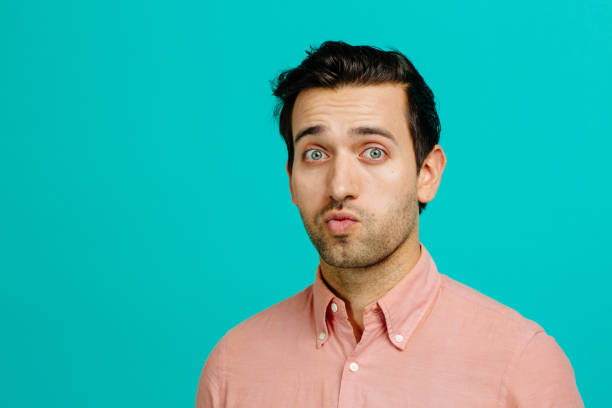 Portrait of a young man with raised eyebrows and pouted mouth Portrait of a young man with raised eyebrows and pouted mouth confusion raised eyebrows human face men stock pictures, royalty-free photos & images