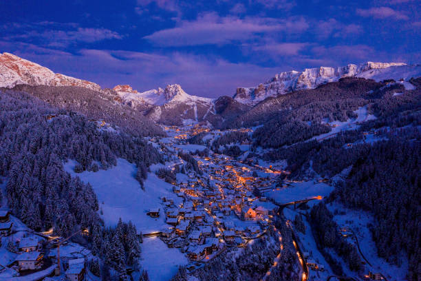 vue de nuit aérienne du village de montagne de station de ski de val gardena dans les dolomites. - ski resort winter snow night photos et images de collection