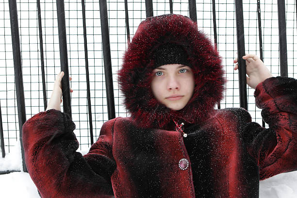 The serious teen poses on metallic grating background