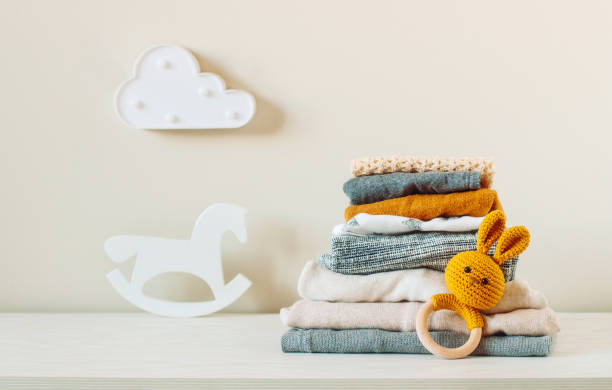 Organic cotton baby clothes on the shelf Organic cotton baby clothes on the shelf in the kids room. baby toys stock pictures, royalty-free photos & images