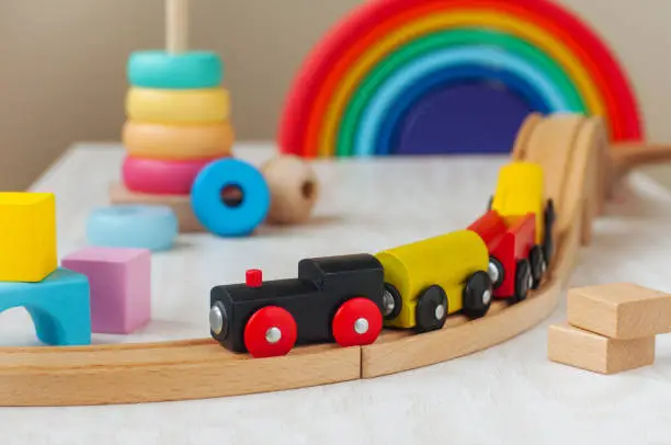 Photo of Wooden toy railway and pyramid in the children room