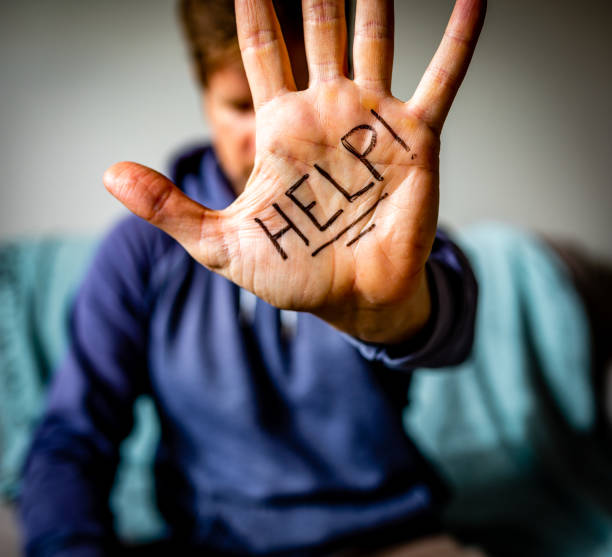 Help Written on Man's Palm Man holds hand to camera with HELP written on palm. addiction stock pictures, royalty-free photos & images