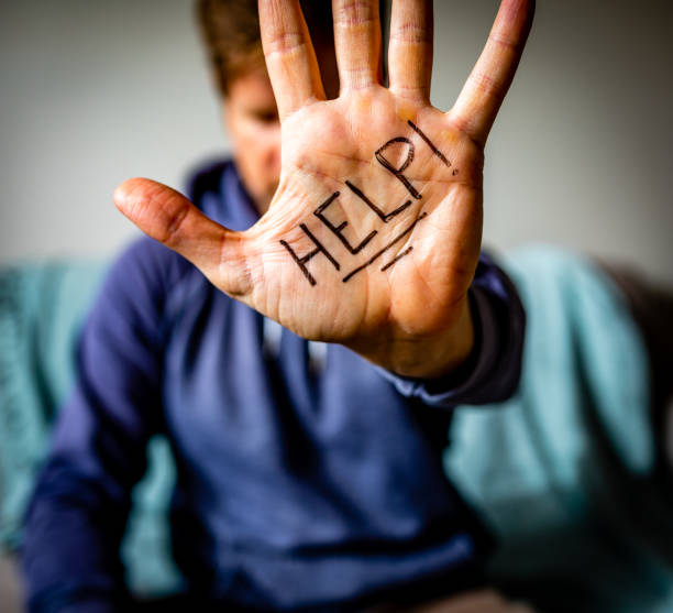 Help Written on Man's Palm Man holds hand to camera with HELP written on palm. drug addiction tattoos stock pictures, royalty-free photos & images