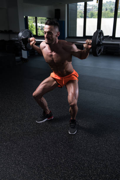 istock Legs Exercise With Barbell In A Gym 1196395409