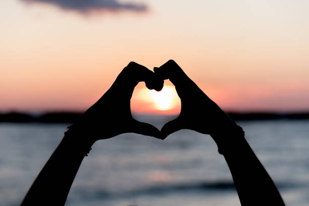 istock Heart with hands at dawn 1196396267