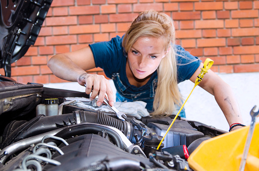 Woman repairing the Car engine using wrench.Woman Mechanic on work,selective focus.Close up