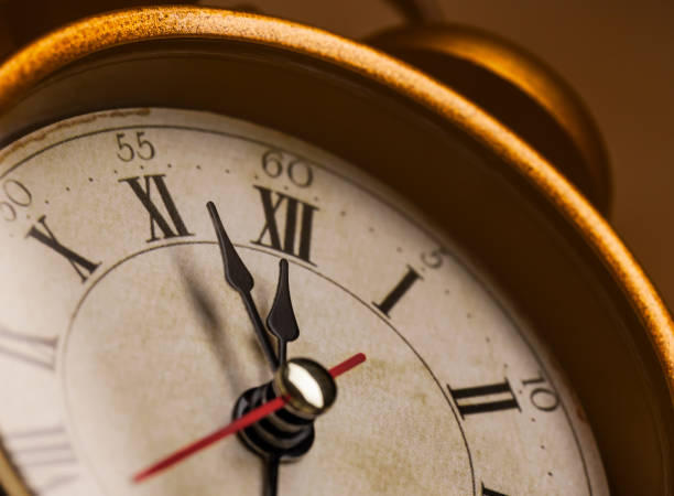 istock Golden vintage alarm clock showing five to twelve 1196400493