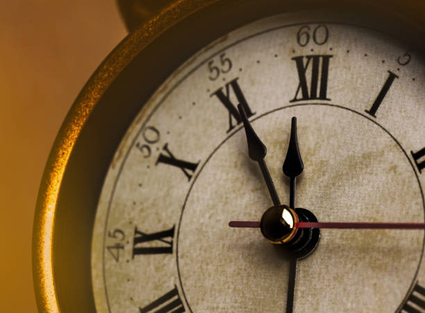 istock Golden vintage alarm clock showing five to twelve 1196400499