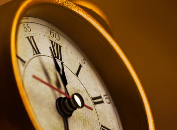 istock Golden vintage alarm clock showing five to twelve 1196400511