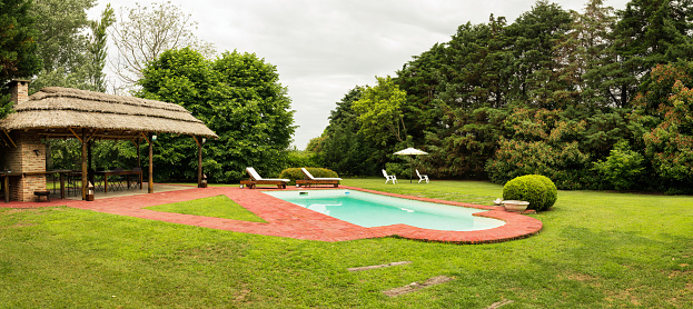 Shot of a swimming pool in backyard of a villa with patio