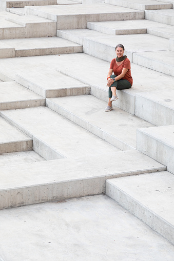 Woman sitting on the geometric steps at the waterfront park in Funchal, Madeira.
