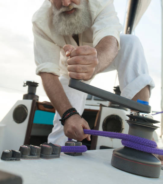 istock elderly man unravels a rope on a sailing boat 1196400575