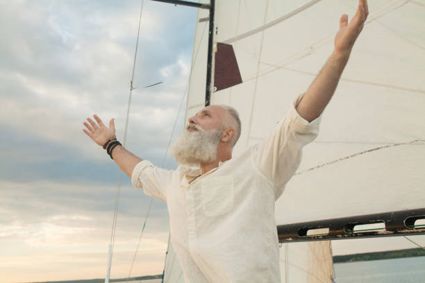 istock bearded man rise hand up on sunset sky 1196401611