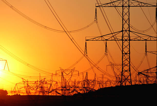 transmission tower   against the sun during sunset stock photo