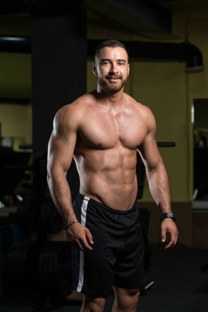 istock Muscular Man Flexing Muscles In Gym 1196403543