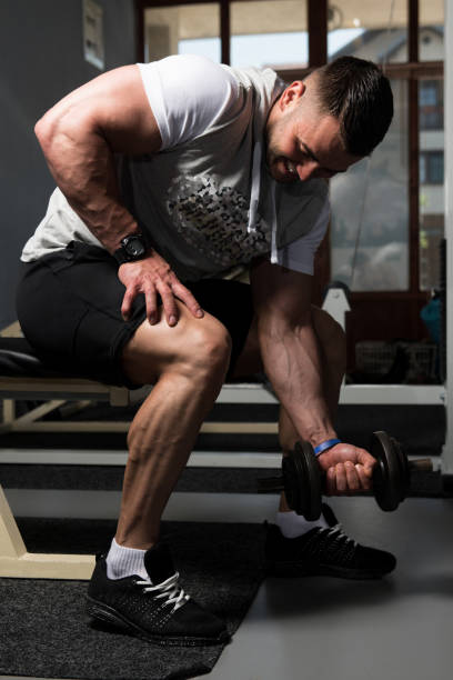 istock Biceps Exercise With Dumbbells In A Gym 1196406274