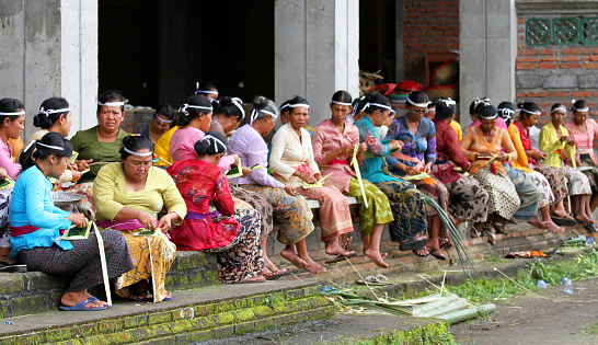 Ketewel, Bali, Indonesia - 19th September 2010. Women of the village prepare temple religious ceremony offerings.