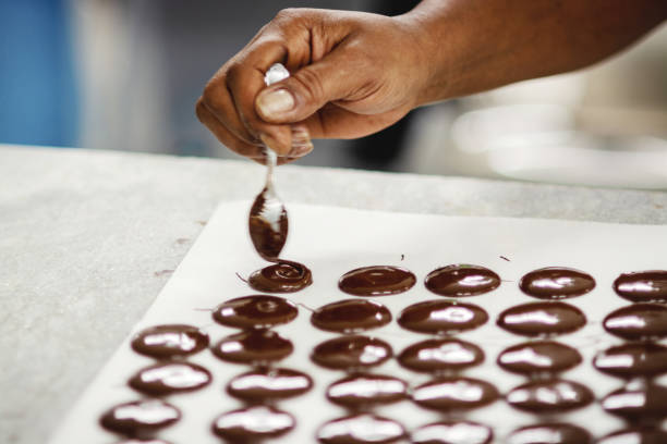 istock Chocolate being produced manually in a factory 1196410055