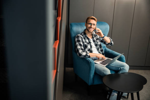 istock Happy young guy holding smartphone and looking at camera 1196410092