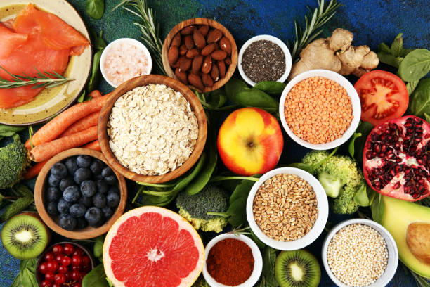 istock Healthy food clean eating selection: fish, fruit, vegetable, cereal, leaf vegetable on rustic background 1196416741