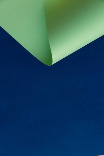 istock Abstract creatively formed neo mint color paper on dark navy blue background 1196417401
