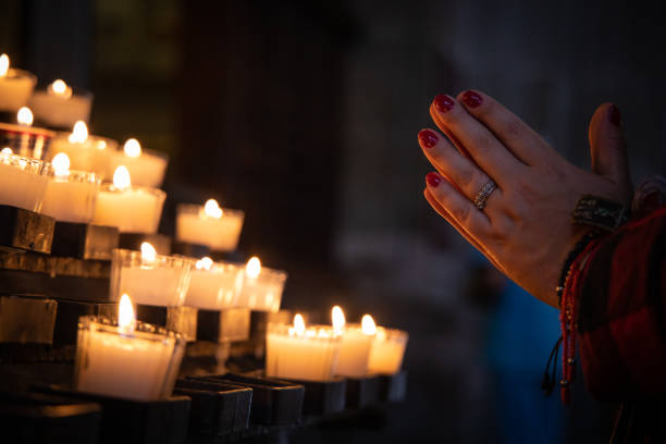 молящиеся руки со свечами в церкви - candle advent christmas church стоковые фото и изображения