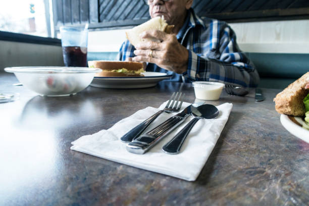 istock Elderly Man in Restaurant Enjoying Egg Salad Sandwich Lunch 1196423602