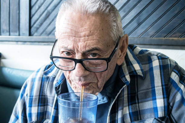 Smiling Elderly Senior Man Drinking Soda in Restaurant