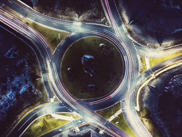 Aerial View of Roundabout Aerial drone view of a roundabout in dusk light. traffic circle photos stock pictures, royalty-free photos & images