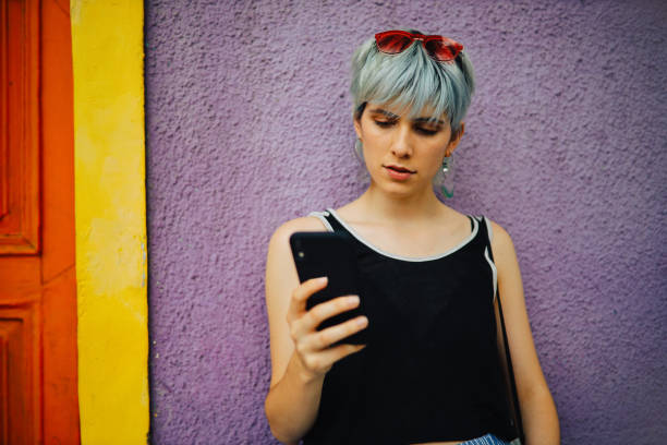 istock Trendy girl using phone outdoors 1196431397