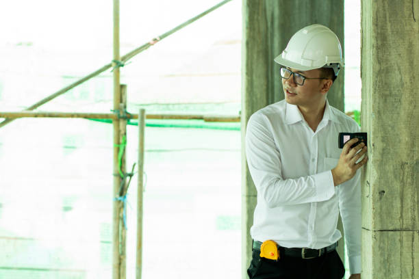 istock Inspector checking distance of pole in construction site 1196431413