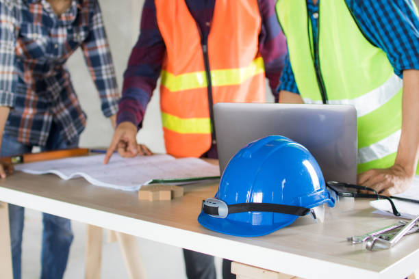 istock Engineer team working and planning on blue print and searching information on laptop 1196432296