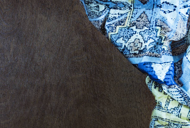 istock Silk colored fabric on dark wood background 1196433574