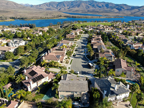 Aerial view of identical residential condo with big lake and mountain on the background during sunny day in Chula Vista, California, USA.