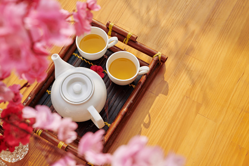 Porcelain teapot and two cups on bamboo tray prepared for Lunar New Year, view from above