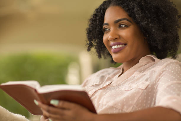 istock Woman smiling holding a book. 1196444715