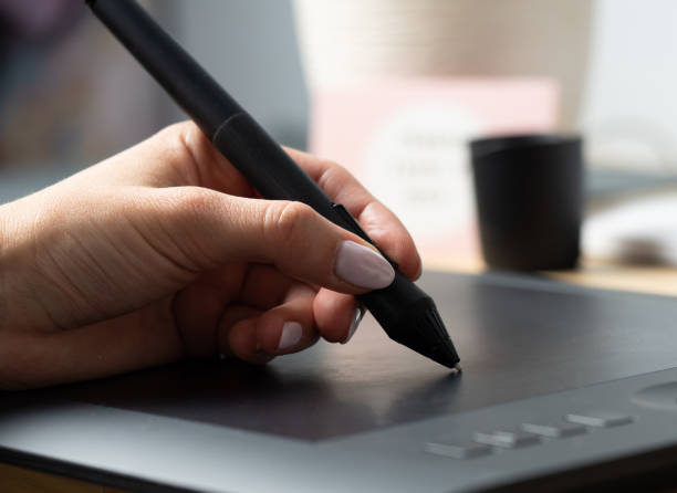 istock The designer works on a graphic tablet with a pen. Creative person at work. 1196455129