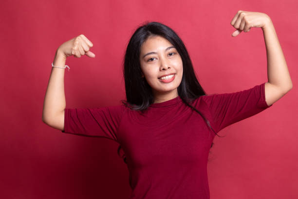 istock Beautiful young Asian woman flex bicep. 1196455918