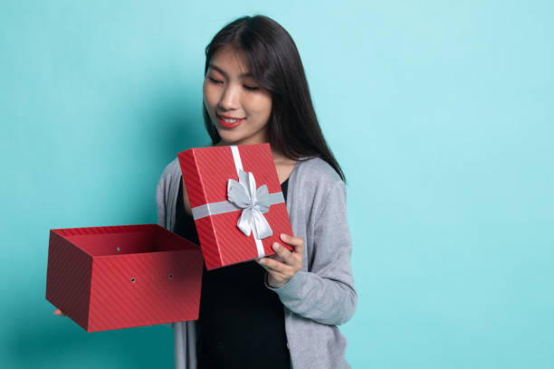 istock Young Asian woman open a golden gift box. 1196465277