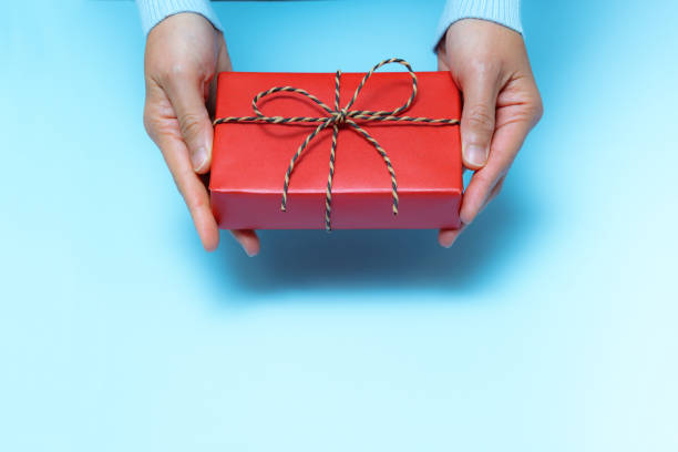 istock Boxing Day loading, young woman hand with a gift box offer to receiver 1196470161