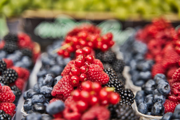 istock Selective focus Various fresh summer berries in the organic market. 1196478534
