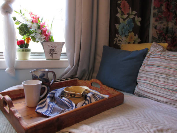 Simple breakfast served on bed Breakfast served on a wooden tray and delivered to a bedroom. The bedroom has healthy amount of sunlight coming through the window country inn stock pictures, royalty-free photos & images