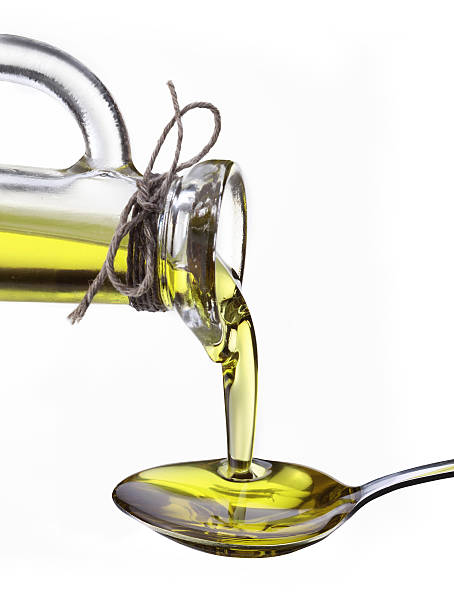 istock Olive oil flowing from carafe into the spoon. 119648353