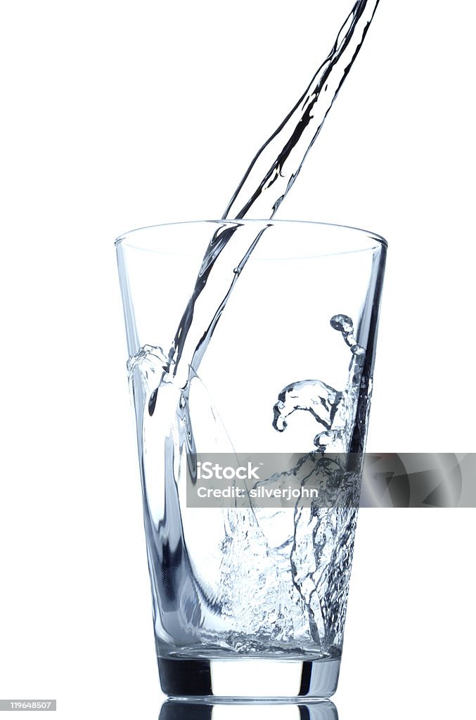 Close-up of water being poured into a clear glass Pouring water into glass isolated on white background Blue Stock Photo