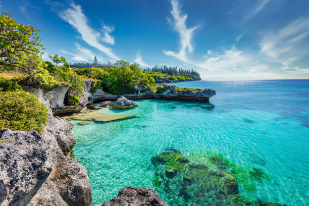 Tadine Bay Lagoon Maré Island New Caledonia Nouvelle Calédonie View over turquoise lagoon at Tadine Bay, south-west coast of Maré Island with beautiful natural rocky lagoon and coral reef to the horizon under sunny blue summer sky. Tadine Bay, Mare Island, Loyalty Islands, New Caledonia, Pacific Ocean Islands. lagoon stock pictures, royalty-free photos & images